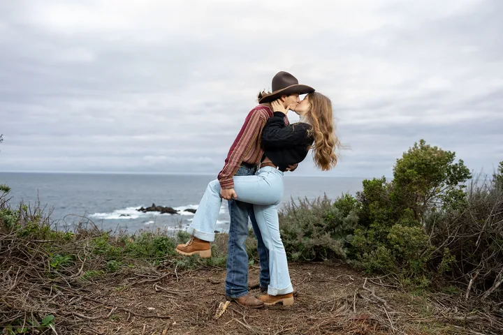 Couple embracing during an outdoor portrait session on the coast