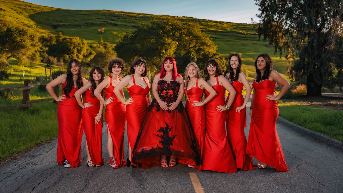 Quinceañera with her full court in coordinated red formalwear