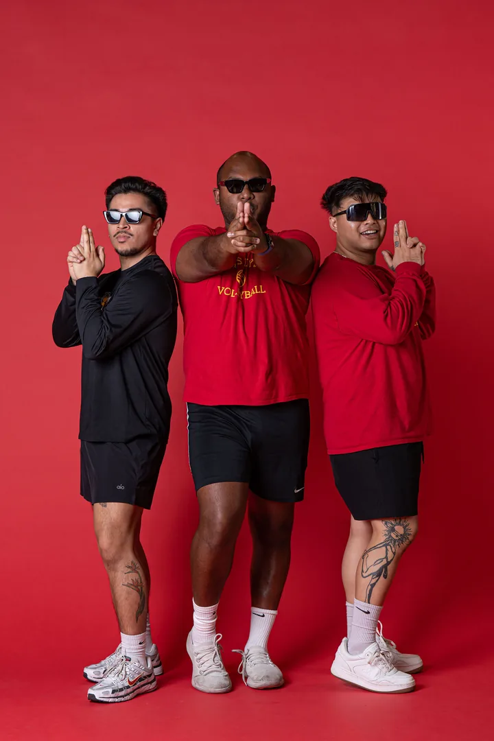 Three Berkeley volleyball athletes in a red studio portrait